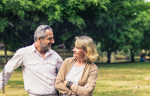 Lovely senior elderly smiling couple man and woman look at each other in romantic moment in the park. Warm heart marriage and lover bonding and relationship. Husband and wife in love photo concept