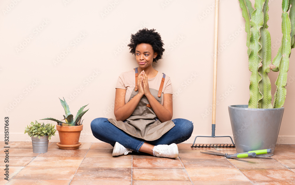 Gardener woman sitting on the floor scheming something Gardener woman sitting on the floor scheming something