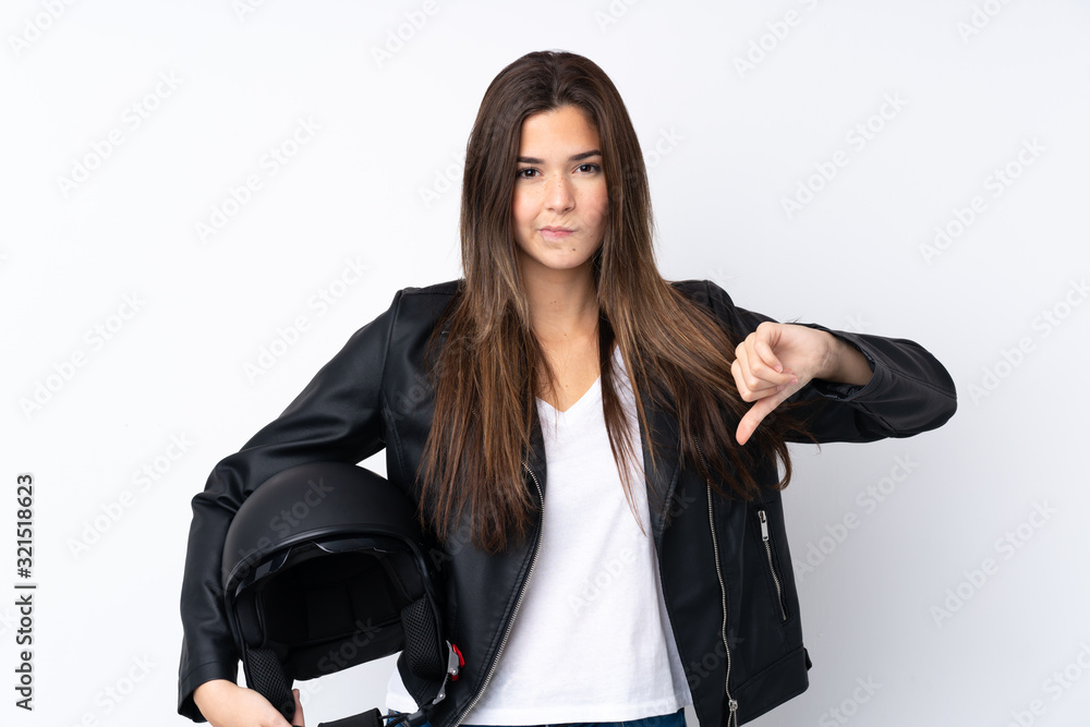 Young woman with a motorcycle helmet over isolated white background showing thumb down sign Young woman with a motorcycle helmet over isolated white background showing thumb down sign