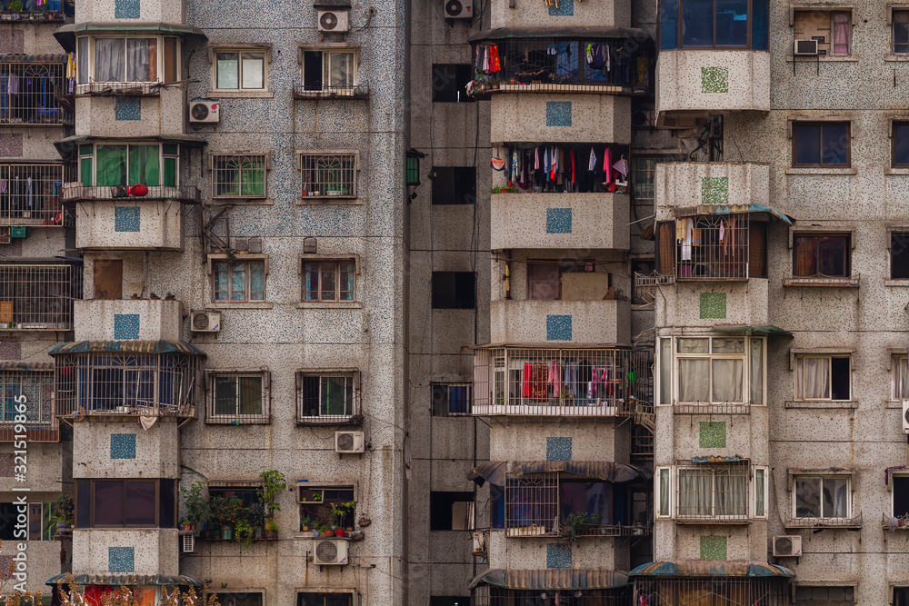 Chongqing, China - March 21, 2018: Frontal view of the facade of a residential building. Concrete, windows, balconies in the Chinese city of Chongqing. Chongqing, China - March 21, 2018: Frontal view of the facade of a residential building. Concrete, windows, balconies in the Chinese city of Chongqing.