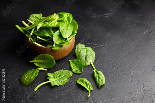 Spinach green fresh leaves in a wooden bowl