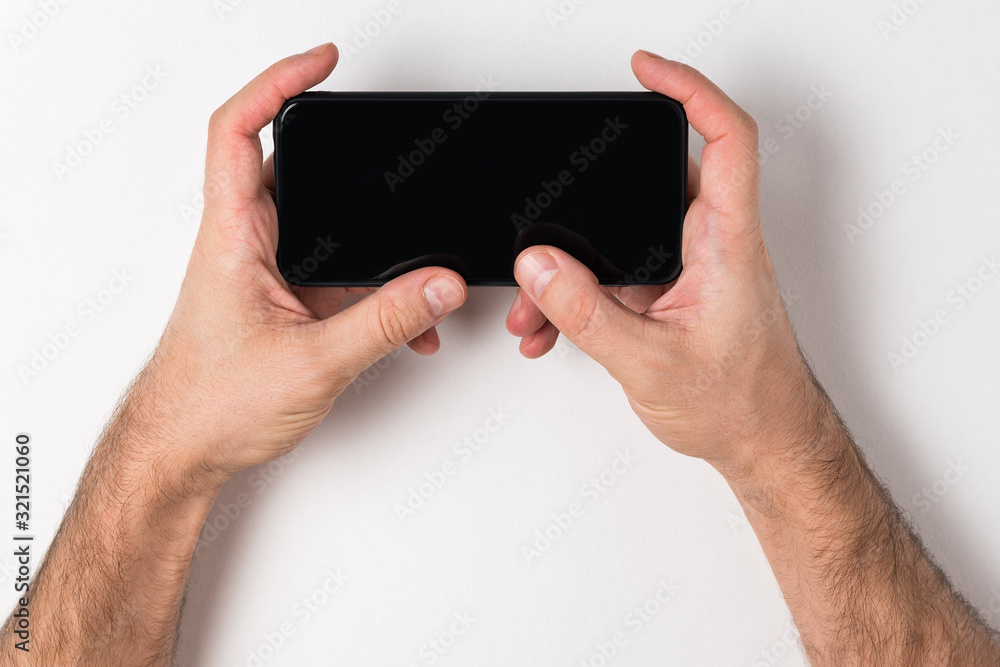 Man holding a smartphone. Empty black screen. White background, copy space Man holding a smartphone. Empty black screen. White background, copy space