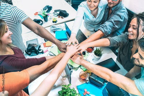 Konstfotografi Young employee startup workers stacking hands at urban studio workspace on entre