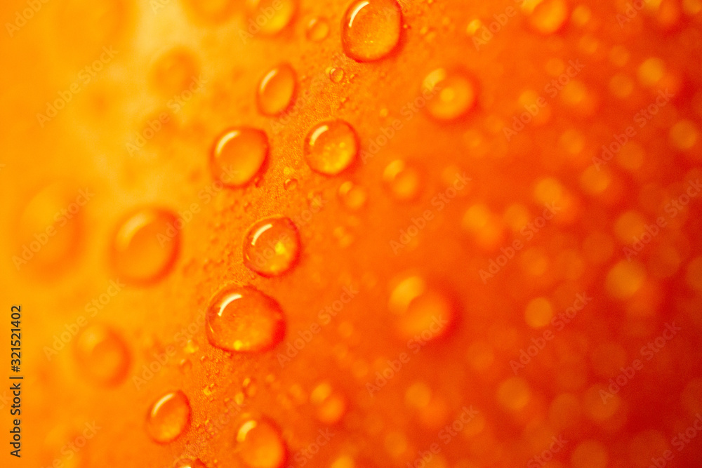 Close-up shot of water droplets on a vivid orange background.