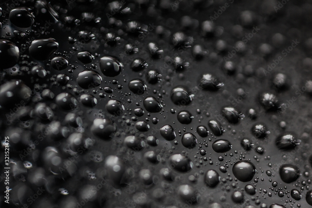 Close-up shot of water droplets on a black background. Close-up shot of water droplets on a black background.