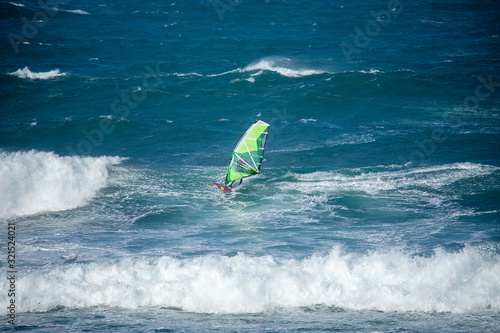 winsurfer amongst waves with strong mistral