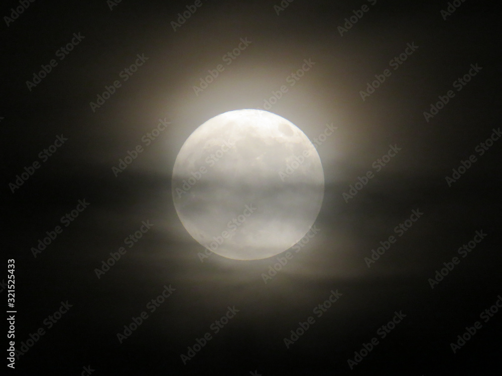 Obraz premium Full moon behind the clouds