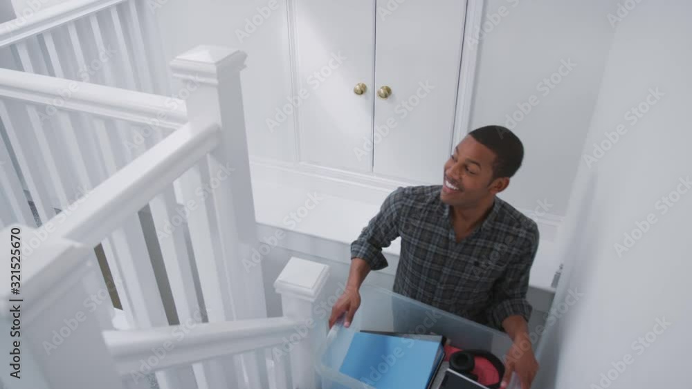 Male College Student Carrying Box Up Stairs Moving Into Accommodation Male College Student Carrying Box Up Stairs Moving Into Accommodation