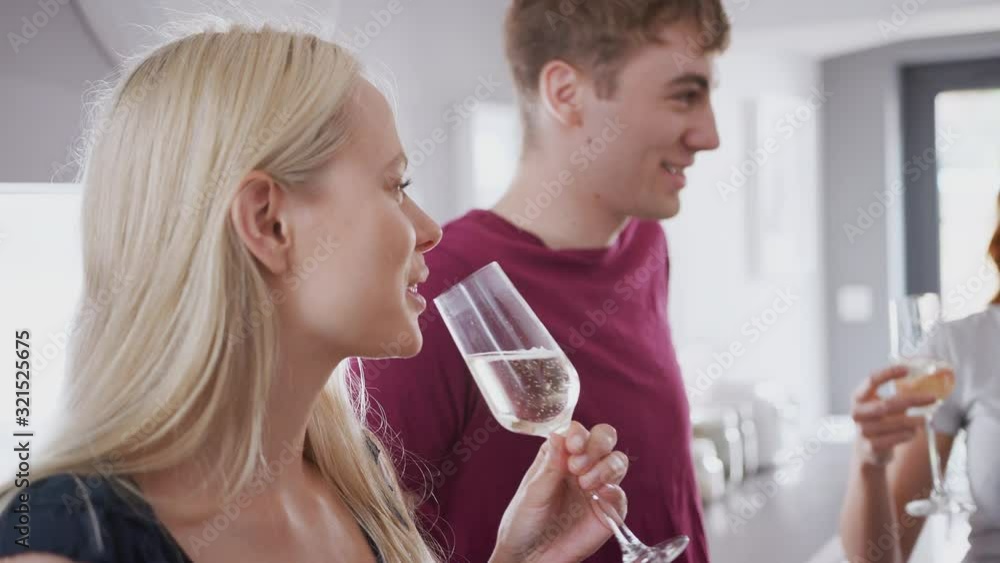 Group Of College Students In Shared House Kitchen Hanging Out And Drinking Together Group Of College Students In Shared House Kitchen Hanging Out And Drinking Together