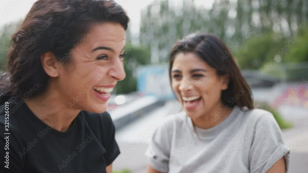 Two Female Friends Meeting In Urban Skate Park Two Female Friends Meeting In Urban Skate Park