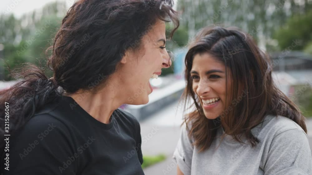 Two Female Friends Meeting In Urban Skate Park Two Female Friends Meeting In Urban Skate Park
