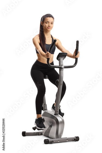 Young sporty female exercising on a stationary bike