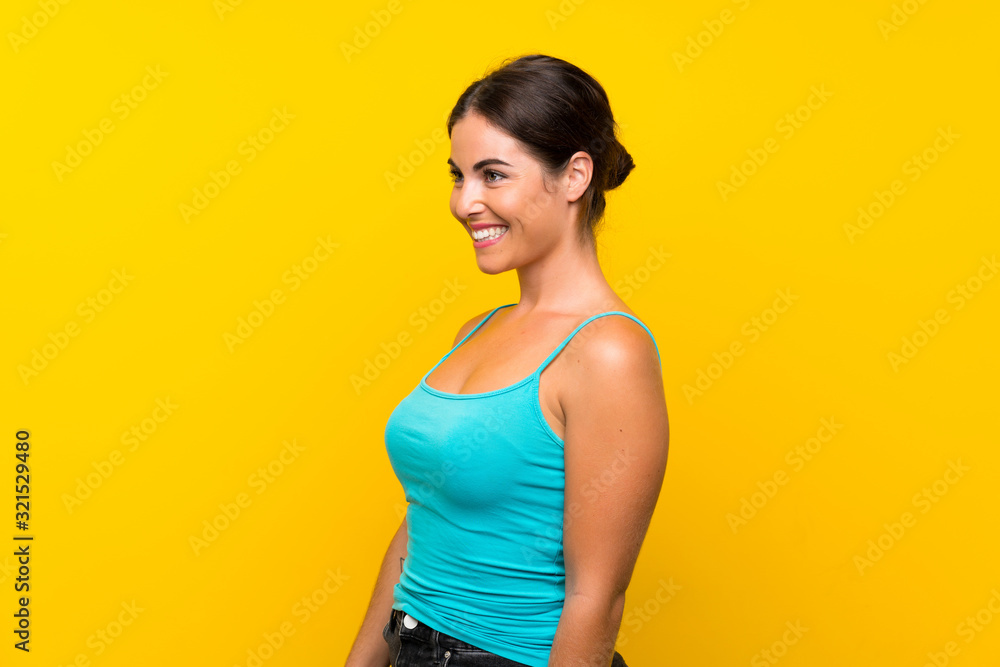 Young woman over isolated yellow background looking to the side Young woman over isolated yellow background looking to the side