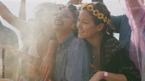 Group Of Young Friends Dancing Behind Barrier At Outdoor Music Festival  photo