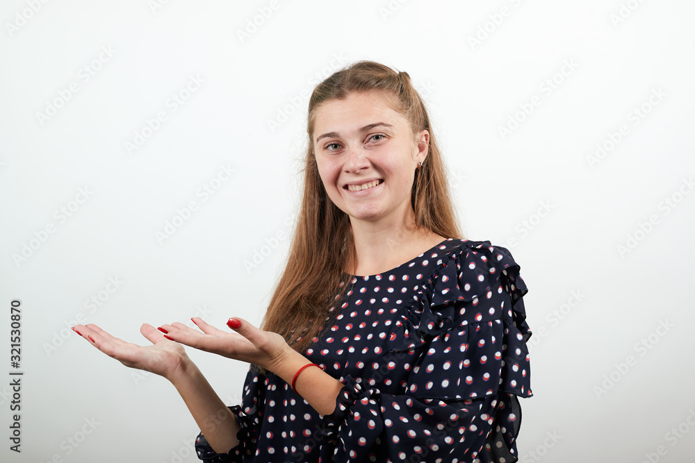 Fair-haired beautiful girl in a black dress with white circles happy smiling holds her hands up on which you can put something Fair-haired beautiful girl in a black dress with white circles happy smiling holds her hands up on which you can put something