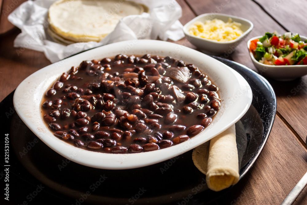 Plato de frijoles cocidos con tortillas y salsa mexicana quesillo en