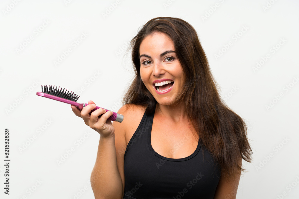 Young woman over isolated white background with hair comb Young woman over isolated white background with hair comb