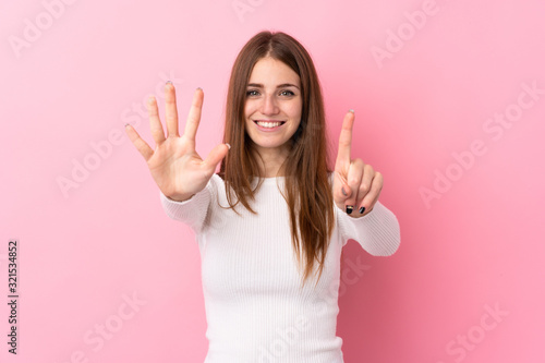 Young woman over isolated pink background counting six with fingers