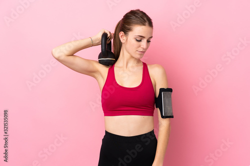 Young sport woman over isolated pink background making weightlifting with kettlebell © luismolinero