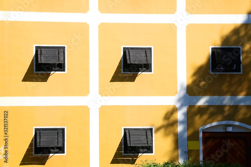 Wooden windows and yellow wall of a historic building in Zapresic, Croatia.