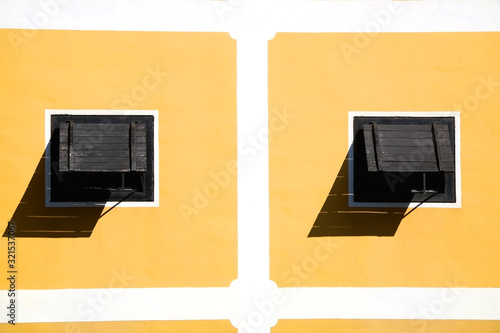 Wooden windows and yellow wall of a historic building in Zapresic, Croatia.