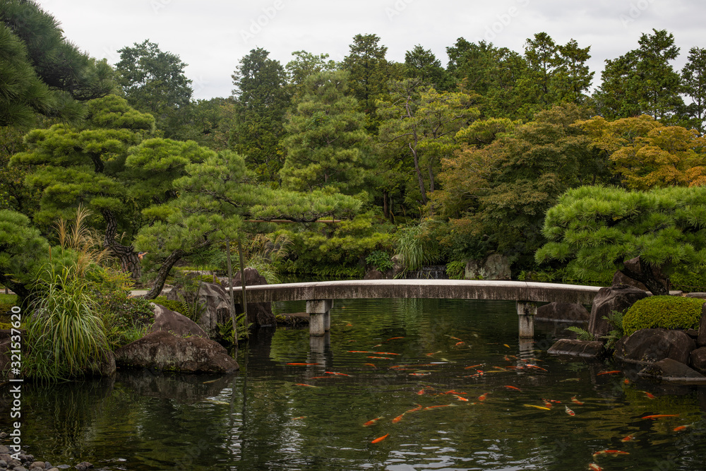 Japan, Himeji, Pond with koi carps and footbridge in Adelaide Himeji Gardens Japan, Himeji, Pond with koi carps and footbridge in Adelaide Himeji Gardens
