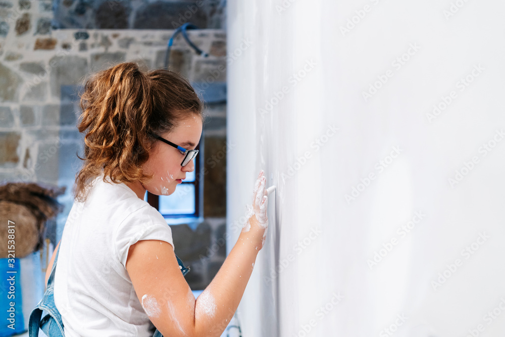 Girl painting with her finger on a wall Girl painting with her finger on a wall