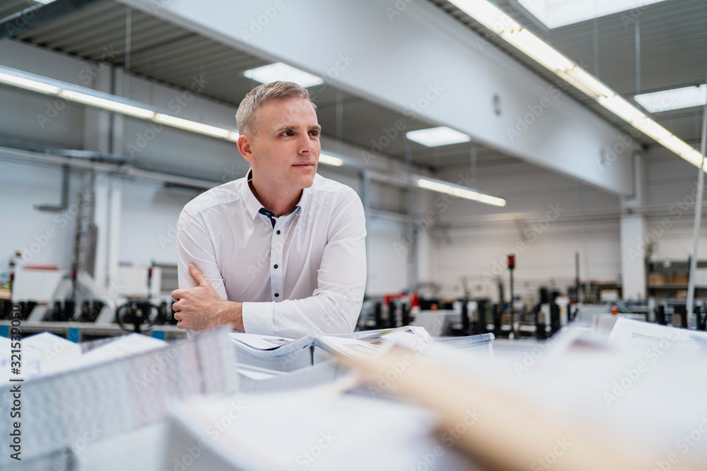 Man in white shirt in a factory looking around Man in white shirt in a factory looking around