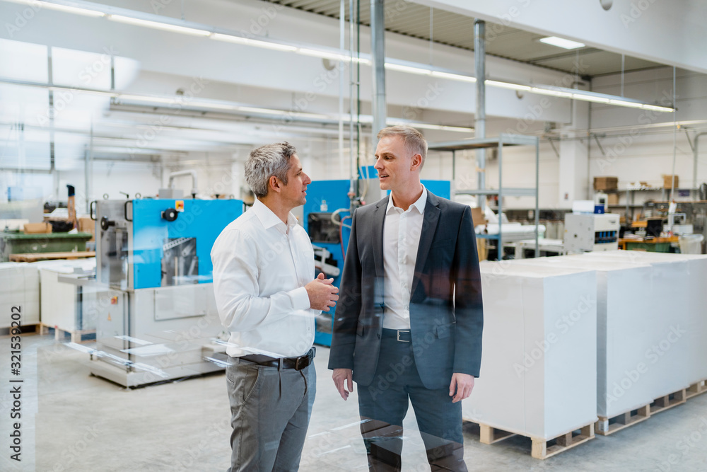 Two businessmen talking in a factory Two businessmen talking in a factory