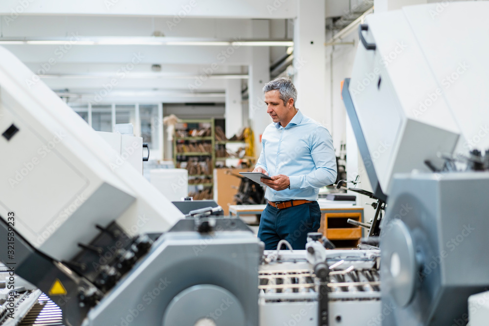 Businessman using a tablet in a factory Businessman using a tablet in a factory