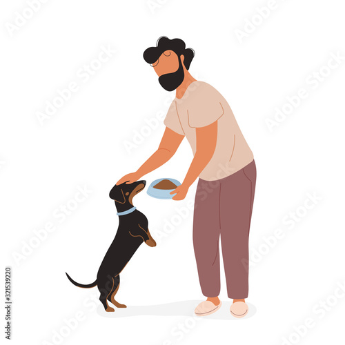 Young man feeding dog and petting on his head