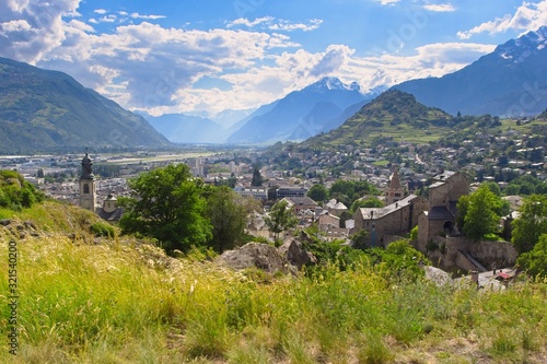 Panoramic view over the city of Sion (Sitten) and into the magnificent Rhone Valley embedded into the Swiss Alps on a beautiful day under a blue sky and with the Mont D'Ogre to the right