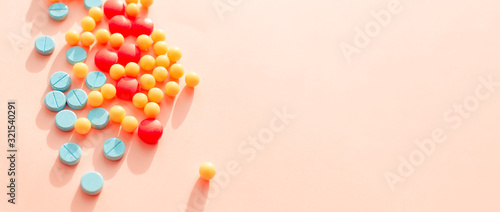 multicolored pharmaceutical pills thermometer a pink background. Copy space. the concept of health. concept  of life. assorted medicines. bright pills. coronavirus