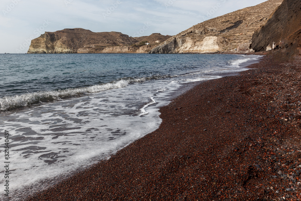 red rocks, huge red boulders and red sand on one of the most famous beaches of Santorini in Greece