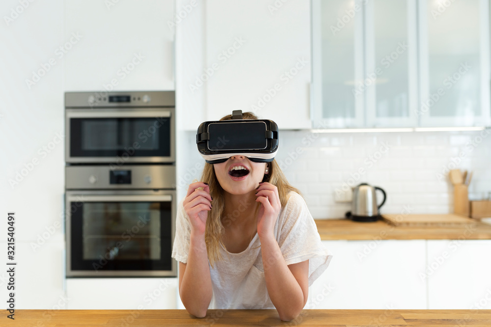 Female teenager in the kitchen with VR glasses Female teenager in the kitchen with VR glasses