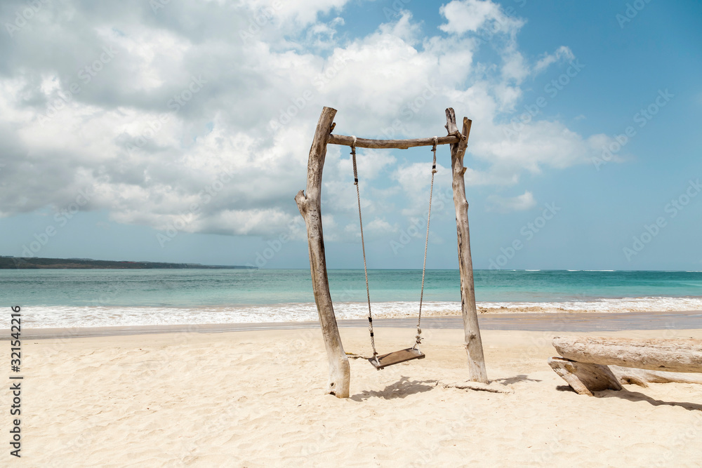 Indonesia, Bali, Jimbaran, Simple wooden swing on sandy coastal beach Indonesia, Bali, Jimbaran, Simple wooden swing on sandy coastal beach