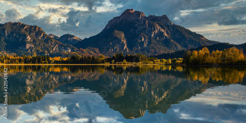 Germany, Bavaria, Ostallgu, Mountains reflected in lake with Neuschwanstein castle in distance