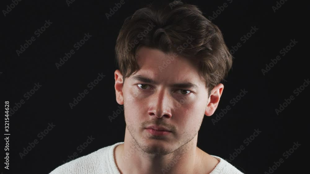 Head And Shoulders Studio Shot Of Unhappy Man Looking At Camera With Sad Expression In Slow Motion Head And Shoulders Studio Shot Of Unhappy Man Looking At Camera With Sad Expression In Slow Motion