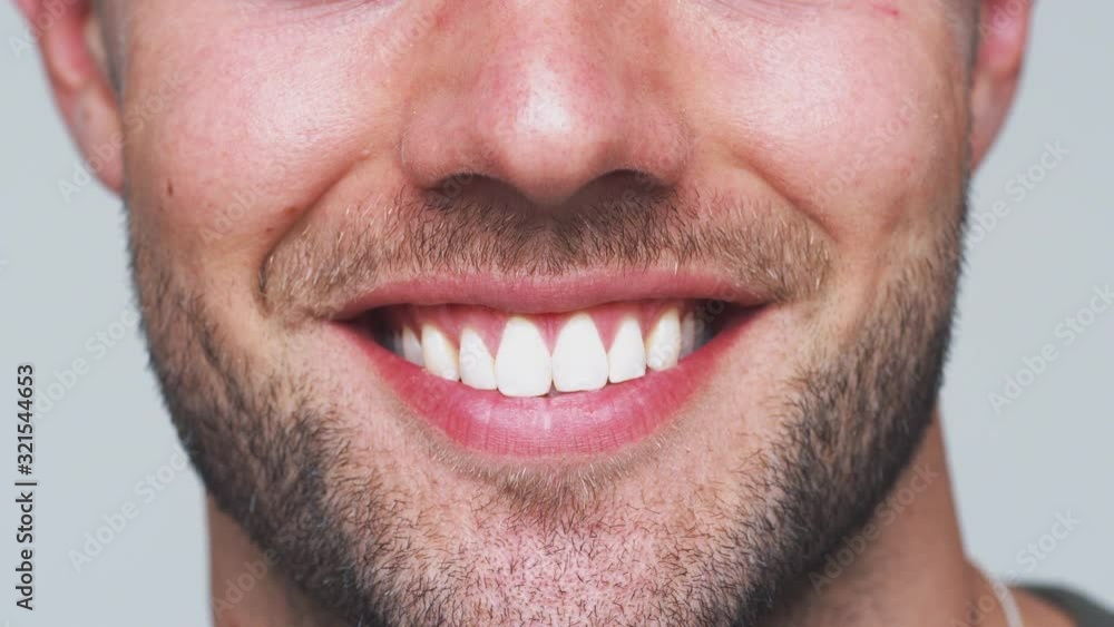 Close Up Of Mouth As Man With Perfect Teeth Smiles At Camera In Studio Close Up Of Mouth As Man With Perfect Teeth Smiles At Camera In Studio