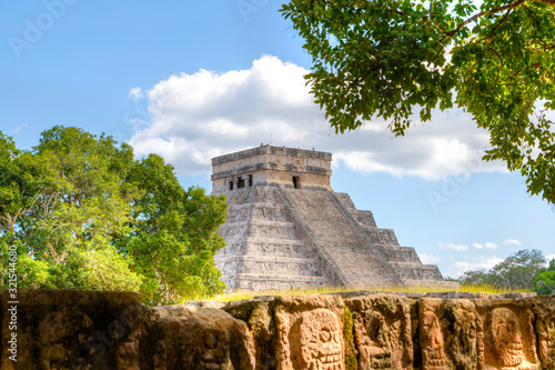 Chichen Itza Pyramid of Kuklukan With Tzompantli or Wall of Skulls in Foreground photo