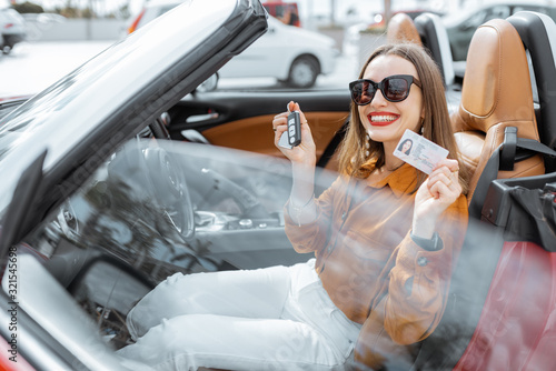 Φωτογραφία Portrait of cheerful woman feeling happy while sitting in the new sports car