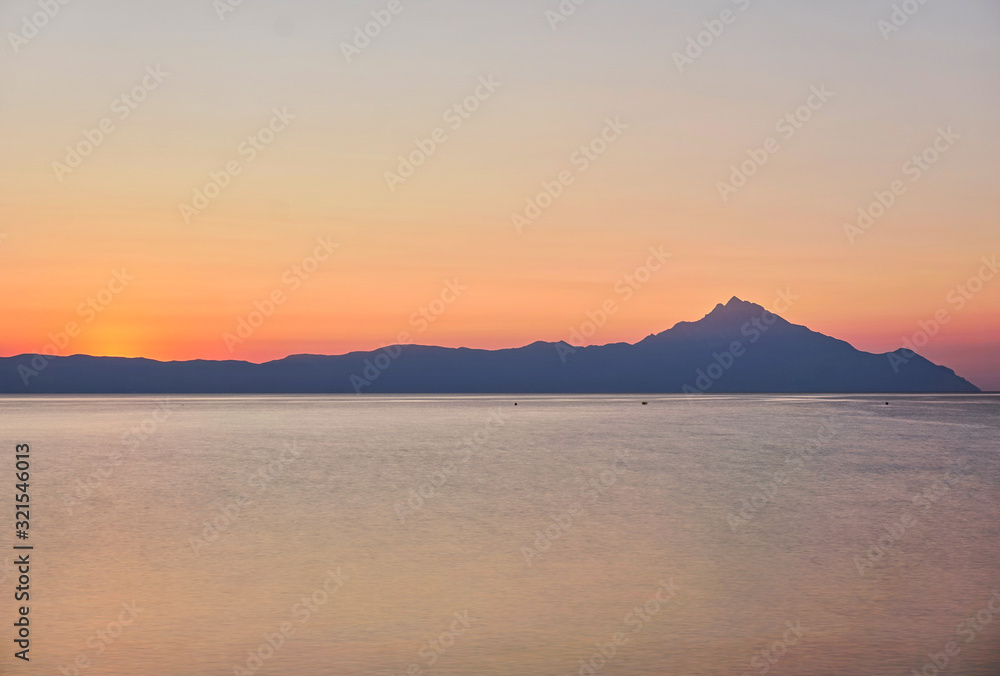 Wonderful sunrise view behind the mountains and next to the sea
