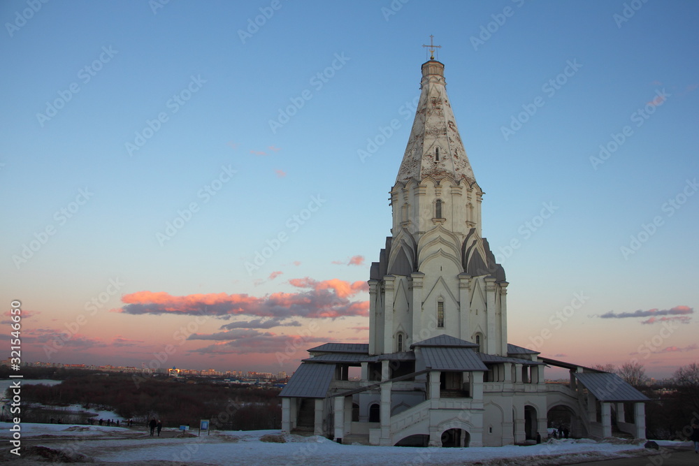 Russian Voznesenskaya church in Moscow museum-reserve Kolomenskoye Park on a winter evening on snow and blue sky background