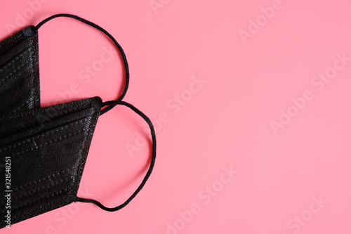 medical masks black color to cover the mouth and nose for protection from bacteria on a pink background. space for text