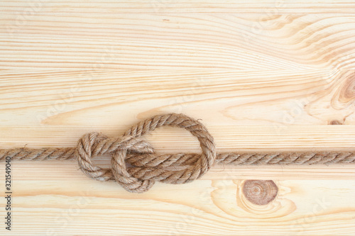 Marine knot used in yachting, bowline knot. Nautical knot on wooden background. photo