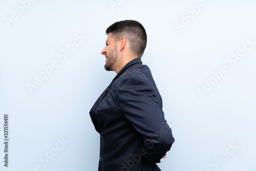 Handsome man over isolated blue background suffering from backache for having made an effort