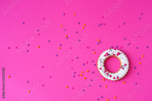 Creative layout made of glazed ring shape rolls, bagels with colorful hearts. Flat lay. Nature concept. Conceptual greeting card. Colorful spring background, space for text. Trendy Decorative Design.