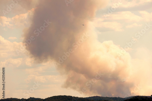 A fire fighting water bombing plane in bush fire smoke in The Blue Mountains in Australia