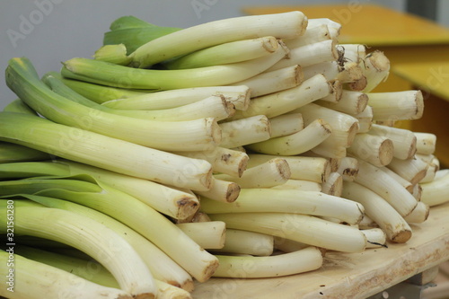 A large pile of stalks of green celery lies on a counter in a store