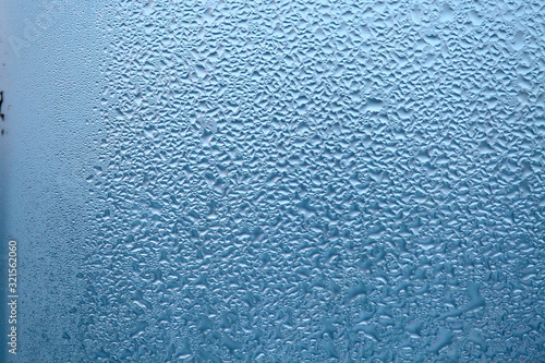 Close Up detail of moisture condensation problems  water drops  texture colorful water drop. Hot water vapor condensed on the cold window glass